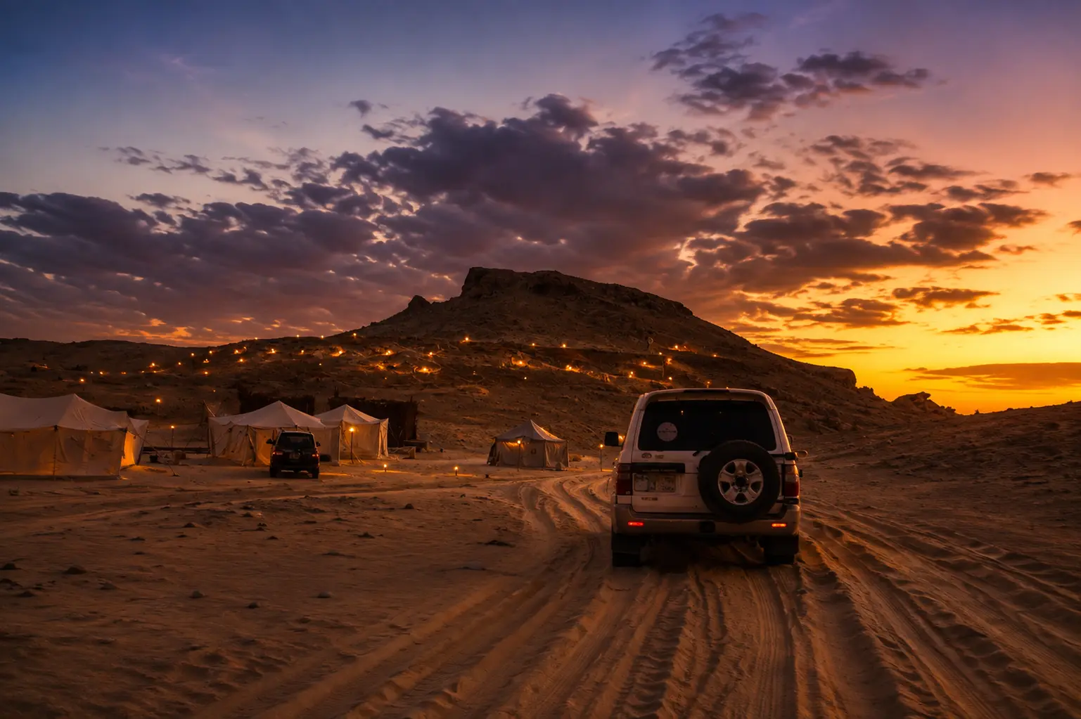 Luxury Siwa Oasis desert camp at sunset with 4x4 vehicles